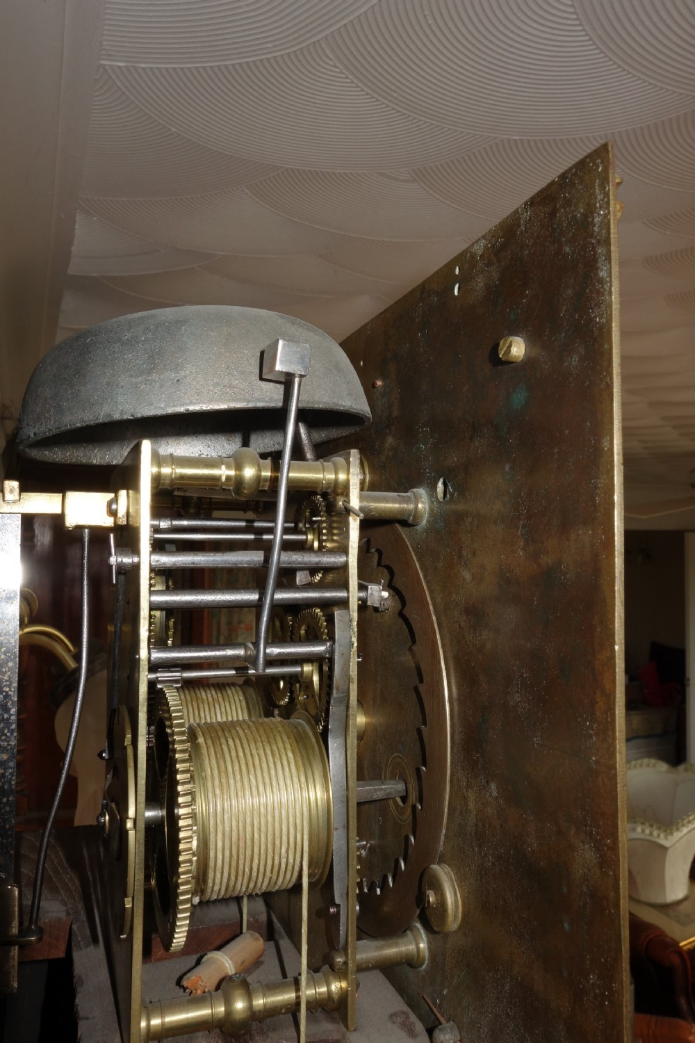 An early Georgian walnut longcase clock featuring a brass dial with Roman numerals, flanked by columns on the hood and a veneered wooden cabinet door. View VIII