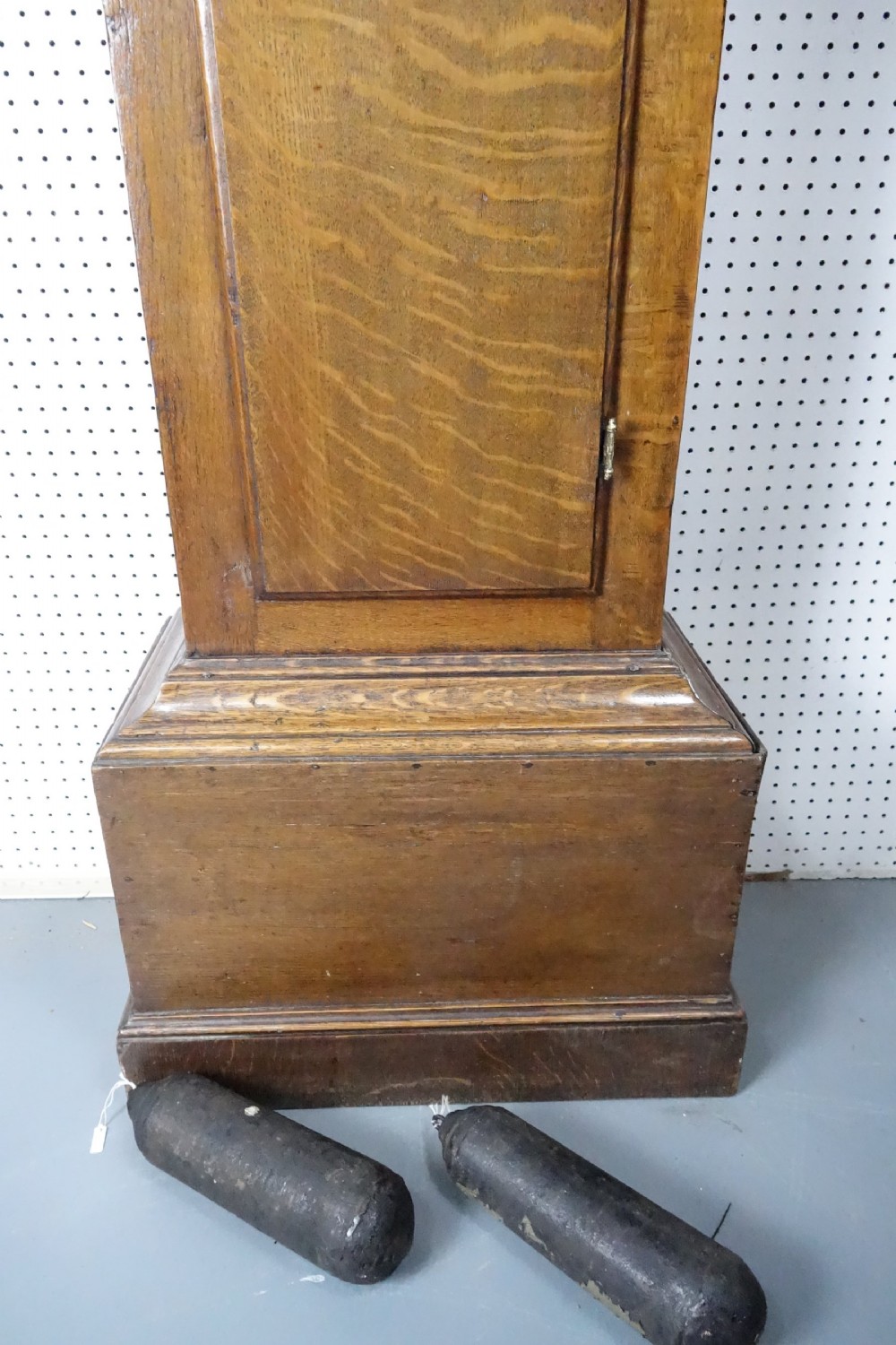 Georgian light oak longcase clock hood with brass finials, arched glass door, and white painted dial featuring Roman numerals. View VII