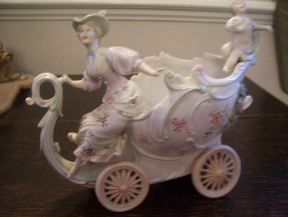 A pair of 19th-century pastel porcelain chariot vases featuring sculpted male and female figures with cherubs and scroll details. View III