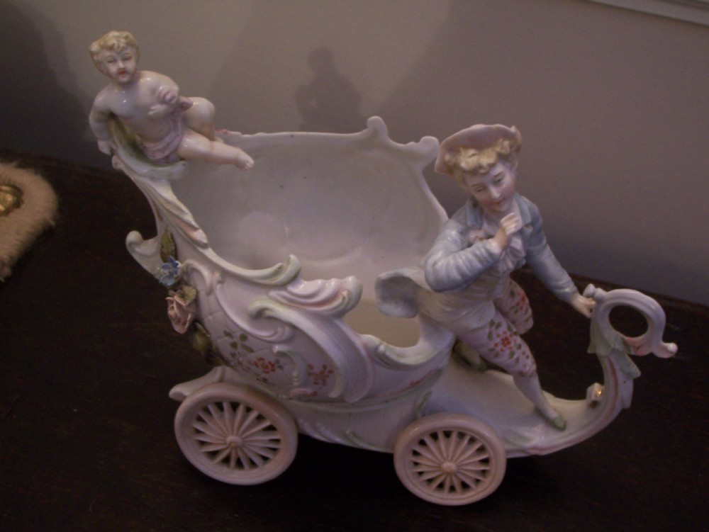 A pair of 19th-century pastel porcelain chariot vases featuring sculpted male and female figures with cherubs and scroll details. View VI