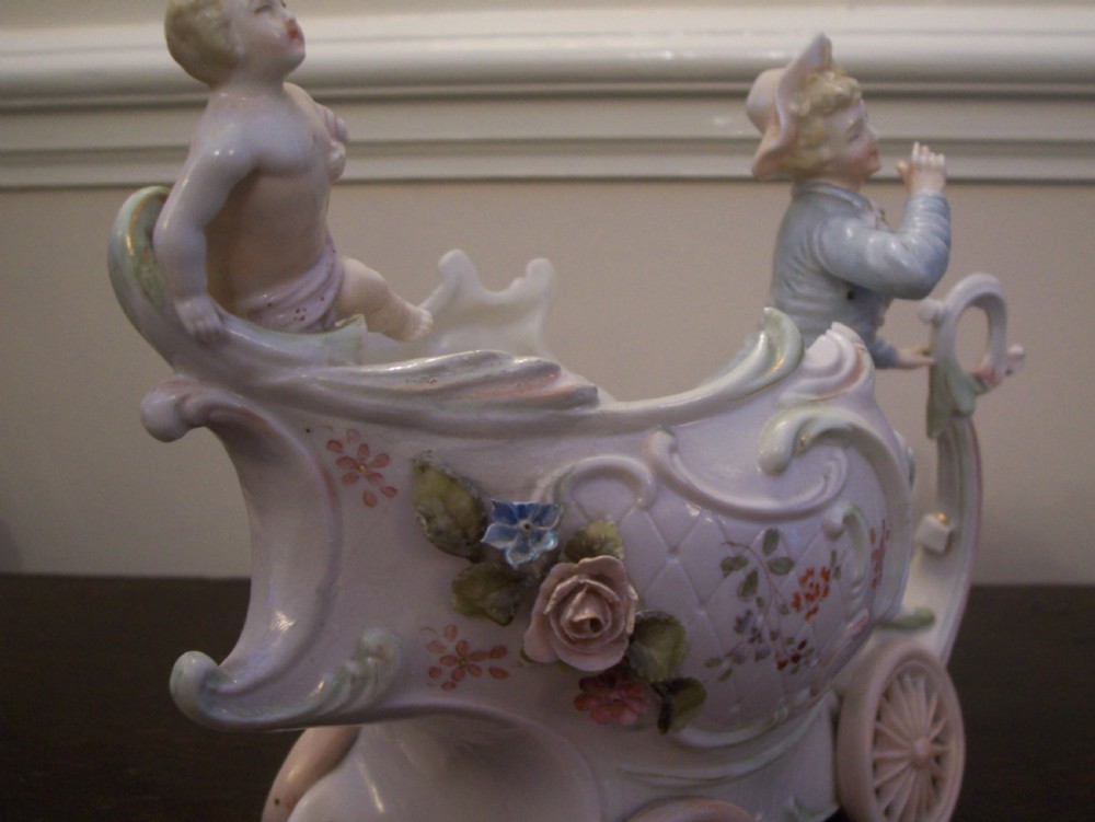 A pair of 19th-century pastel porcelain chariot vases featuring sculpted male and female figures with cherubs and scroll details. View VII