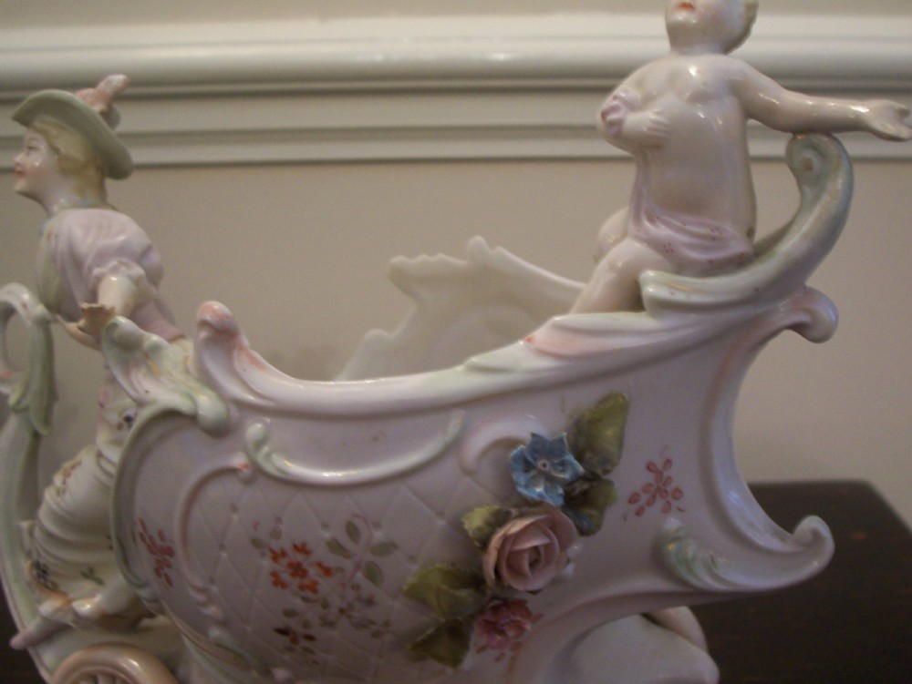 A pair of 19th-century pastel porcelain chariot vases featuring sculpted male and female figures with cherubs and scroll details. View VIII