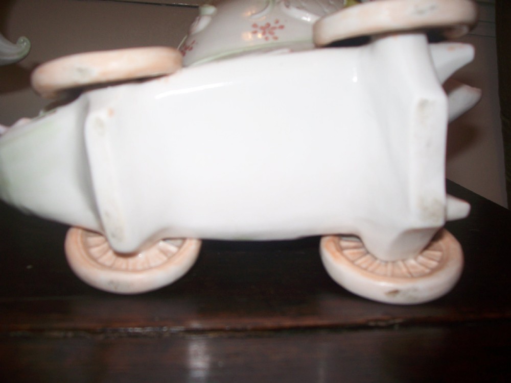A pair of 19th-century pastel porcelain chariot vases featuring sculpted male and female figures with cherubs and scroll details. View X