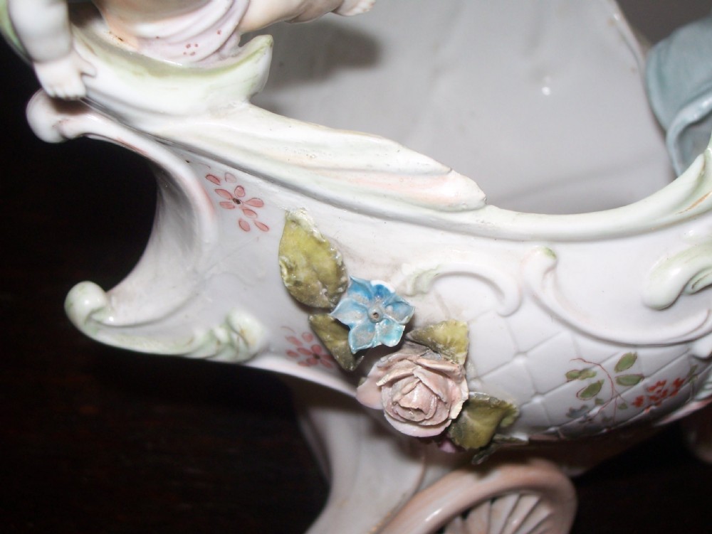 A pair of 19th-century pastel porcelain chariot vases featuring sculpted male and female figures with cherubs and scroll details. View XI