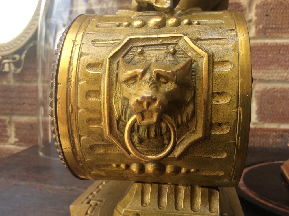 A mid nineteenth-century French gilt ormolu mantel clock featuring a classical figure, blue Sevres-style porcelain dial, and panels, set under a clear glass dome on a wooden base. View IX