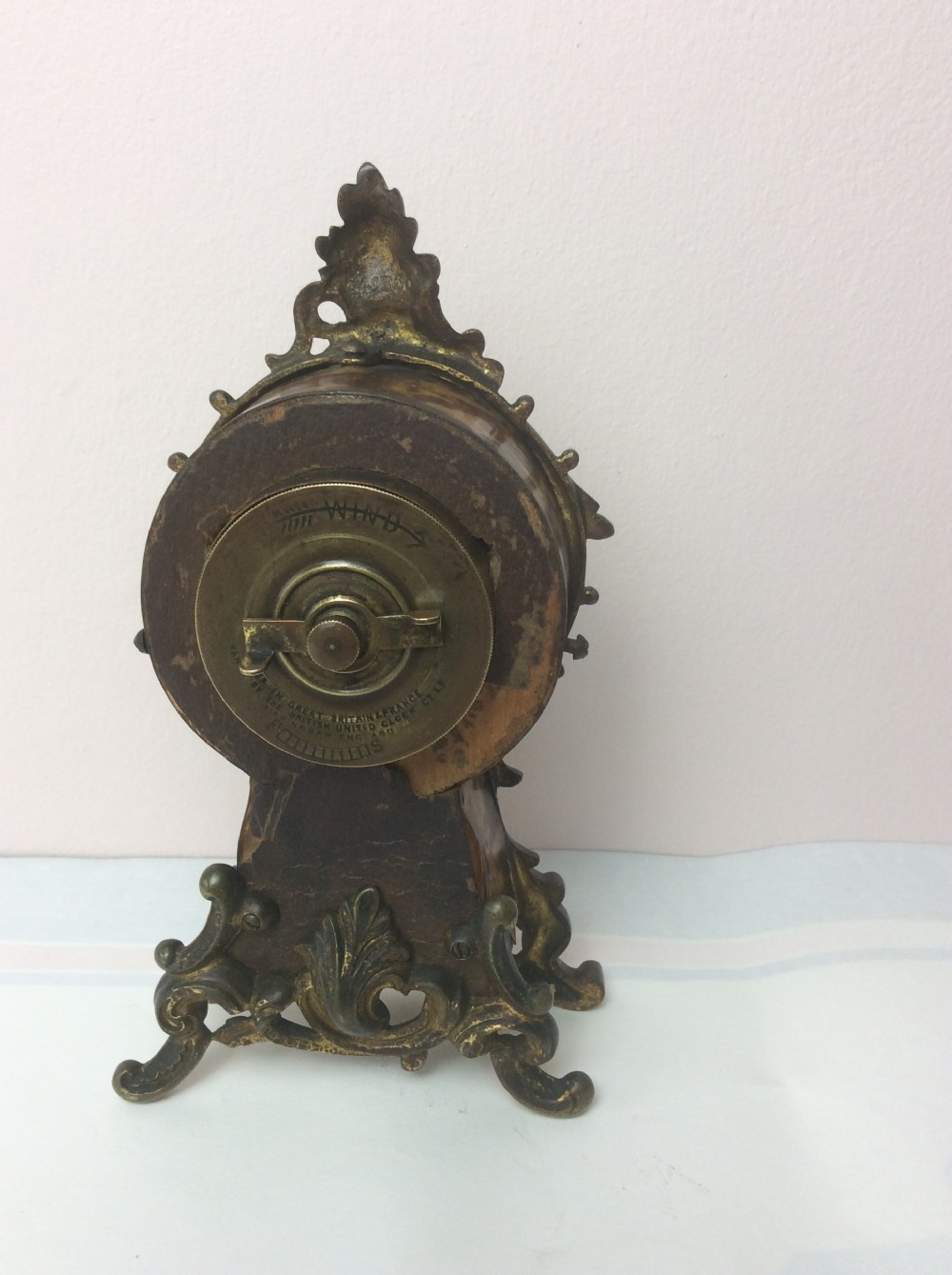 A petite late 19th-century Rococo Revival style gilt ormolu boudoir clock with faux tortoiseshell panel inserts and a circular Roman numeral dial. View III