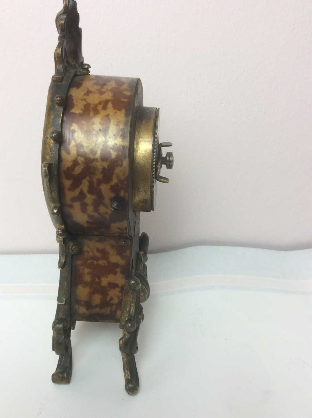 A petite late 19th-century Rococo Revival style gilt ormolu boudoir clock with faux tortoiseshell panel inserts and a circular Roman numeral dial. View IV