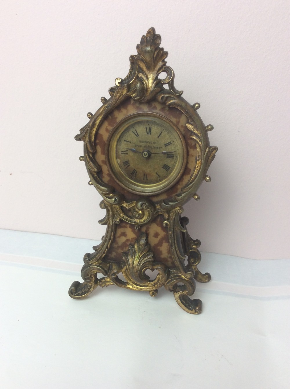 A petite late 19th-century Rococo Revival style gilt ormolu boudoir clock with faux tortoiseshell panel inserts and a circular Roman numeral dial. View VI