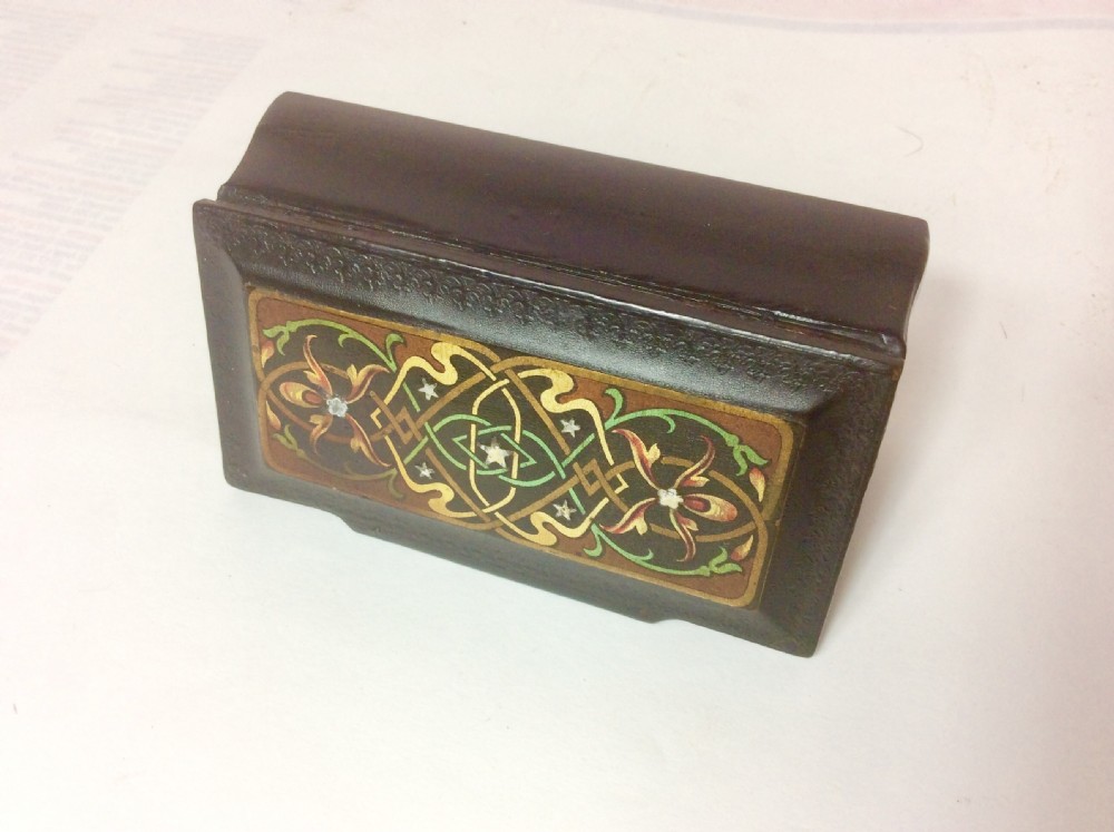A rectangular black lacquered papier-mache table snuff box featuring hand-painted floral scrollwork and star-shaped mother-of-pearl inlays on the lid. View II