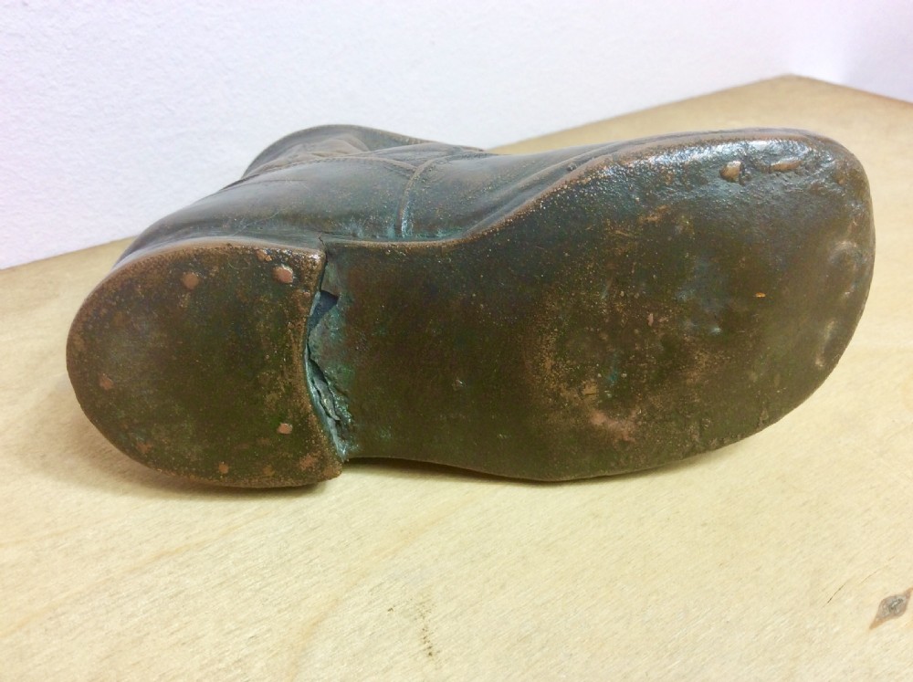 An early twentieth-century infant leather shoe preserved with an electroplated copper coating, featuring tied laces and creased detail. View III