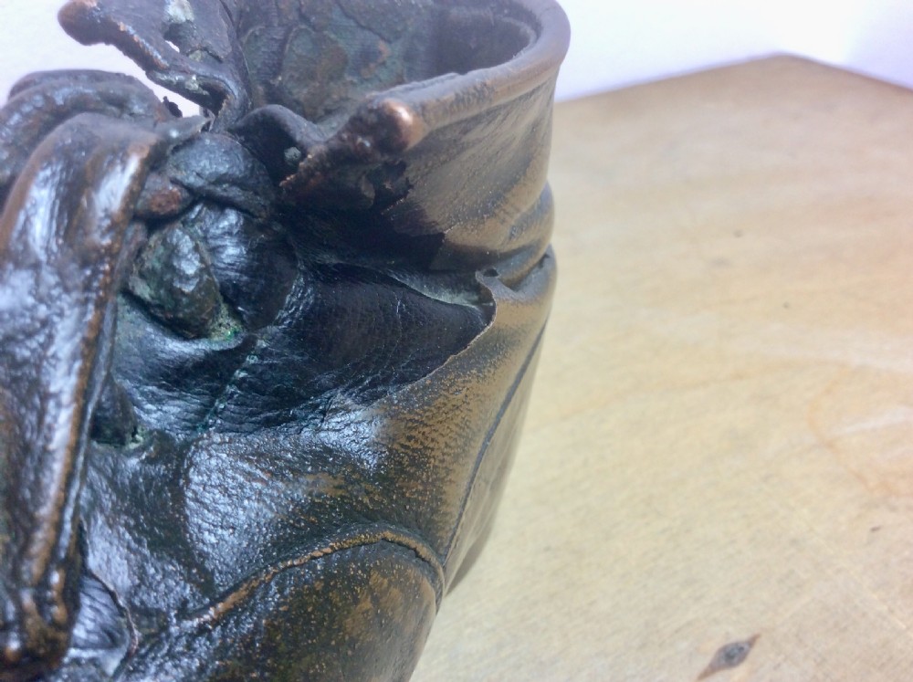 An early twentieth-century infant leather shoe preserved with an electroplated copper coating, featuring tied laces and creased detail. View IV