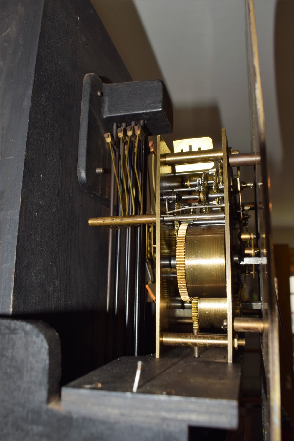 An antique dark mahogany longcase clock featuring an arched hood, engraved silvered dial with Roman numerals, and side fretwork sound apertures. View VII