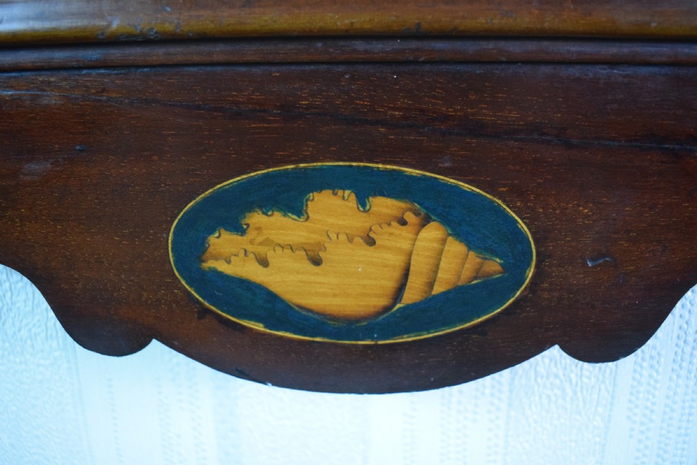 A 19th-century mahogany wall mirror featuring a bevelled oval glass plate, scroll fretwork border, gilded urn finial, and shell marquetry inlay. View III