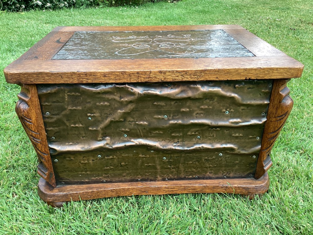An Arts and Crafts oak log box featuring hammered copper panels with decorative repousse detailing and riveted edges. View III