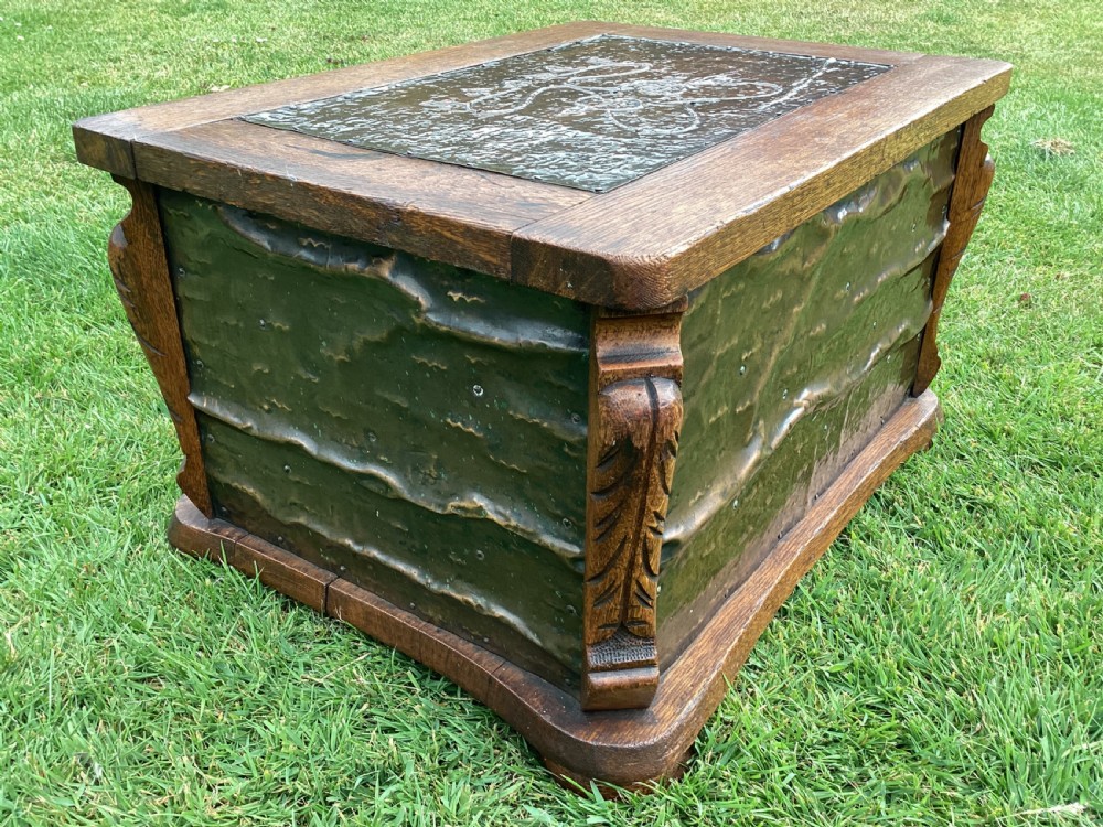 An Arts and Crafts oak log box featuring hammered copper panels with decorative repousse detailing and riveted edges. View IV