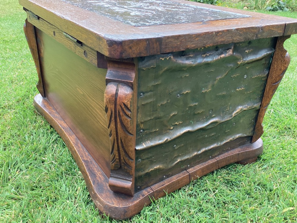 An Arts and Crafts oak log box featuring hammered copper panels with decorative repousse detailing and riveted edges. View V