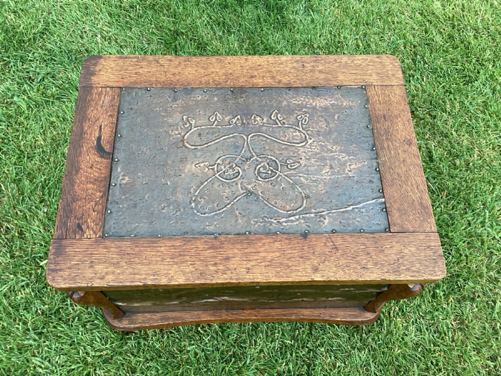 An Arts and Crafts oak log box featuring hammered copper panels with decorative repousse detailing and riveted edges. View VII