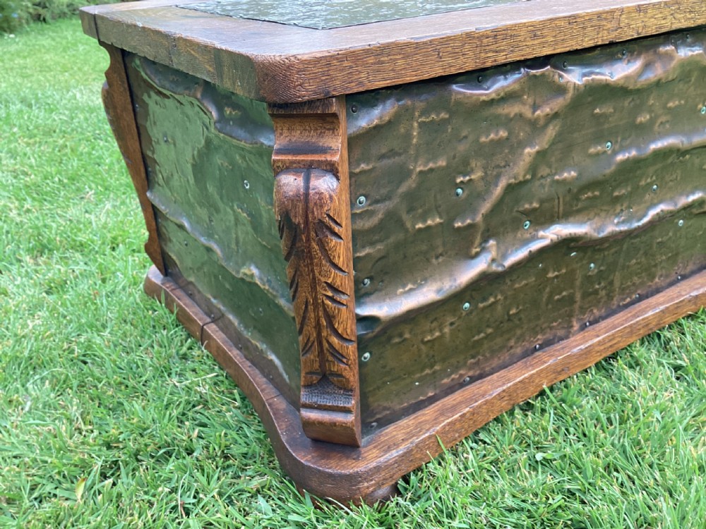 An Arts and Crafts oak log box featuring hammered copper panels with decorative repousse detailing and riveted edges. View VIII