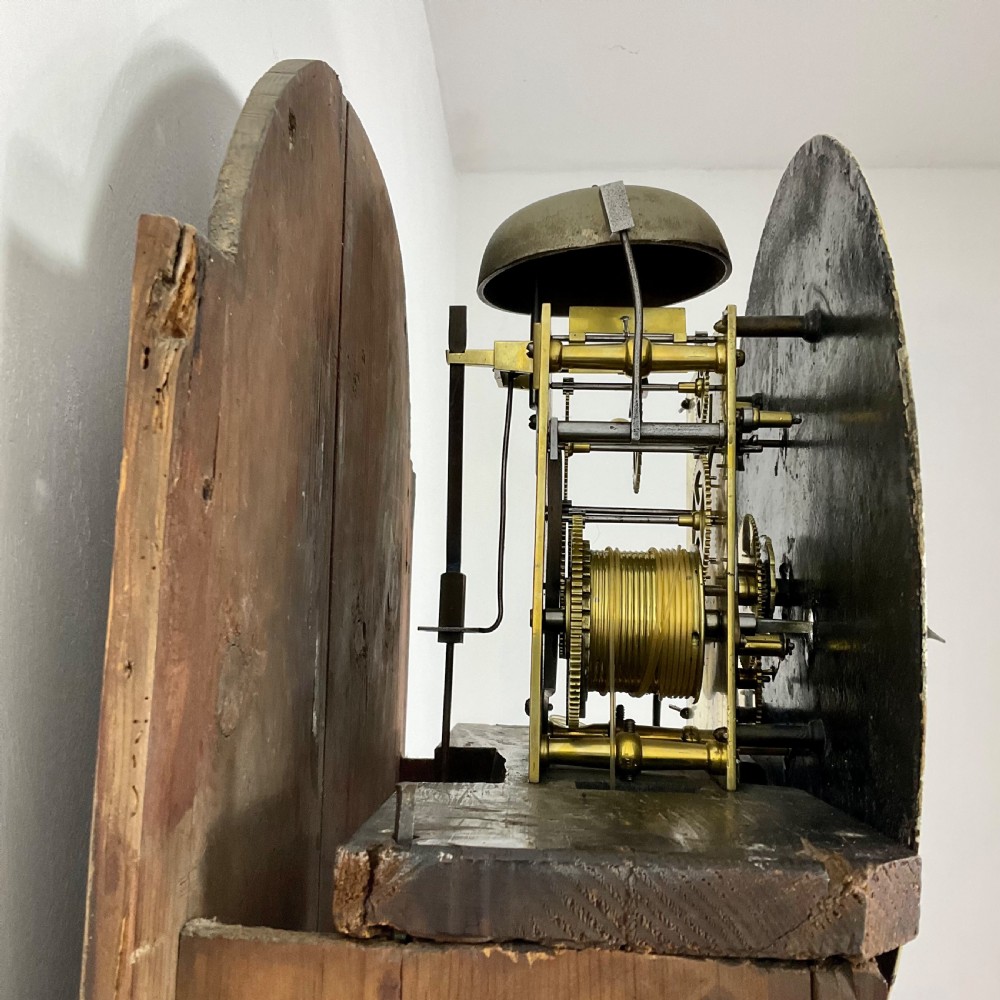 A Regency period flame mahogany longcase clock featuring a circular brass bezel, Roman numerals, subsidiary seconds display, and an arched bonnet. View XIII