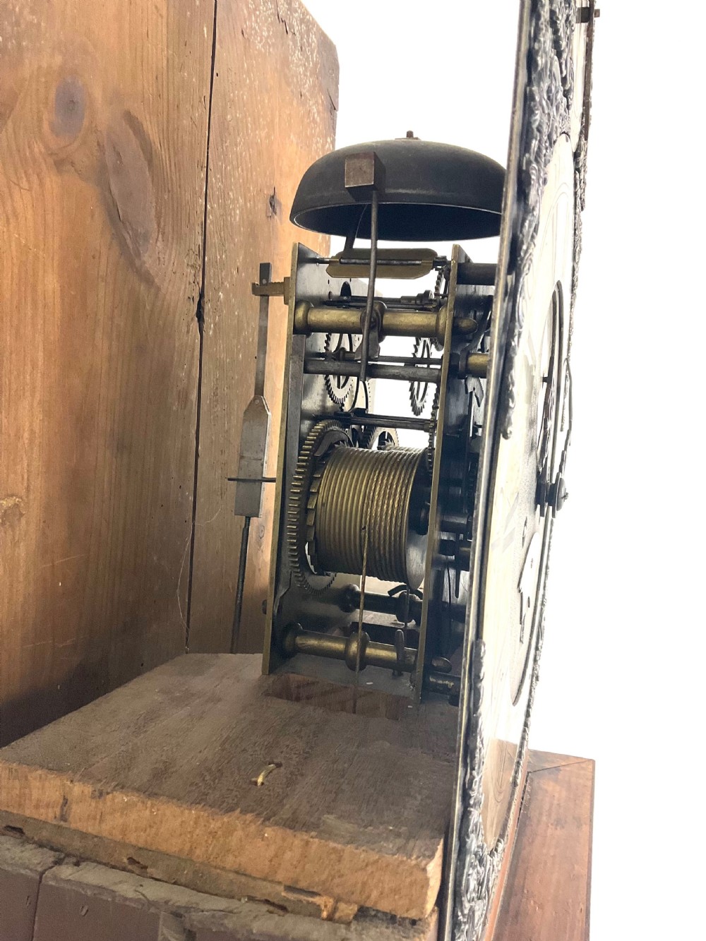 A Georgian mahogany longcase clock hood featuring a swan-neck pediment, brass eagle finial, reeded columns, and an engraved brass dial. View V