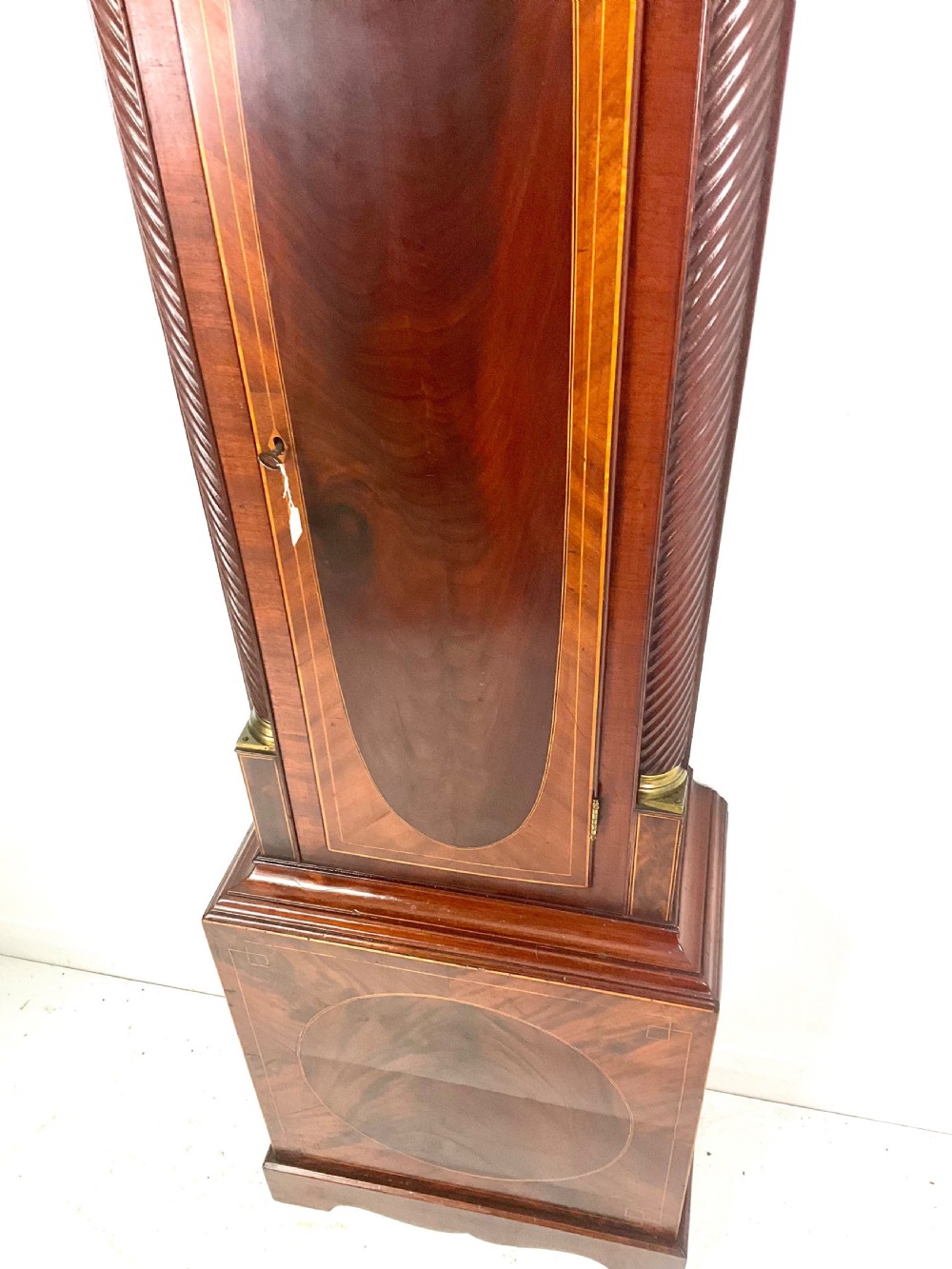 A late Georgian mahogany longcase clock featuring a swan-neck pediment, twisted columns, and an arched dial with silvered chapter ring. View IV