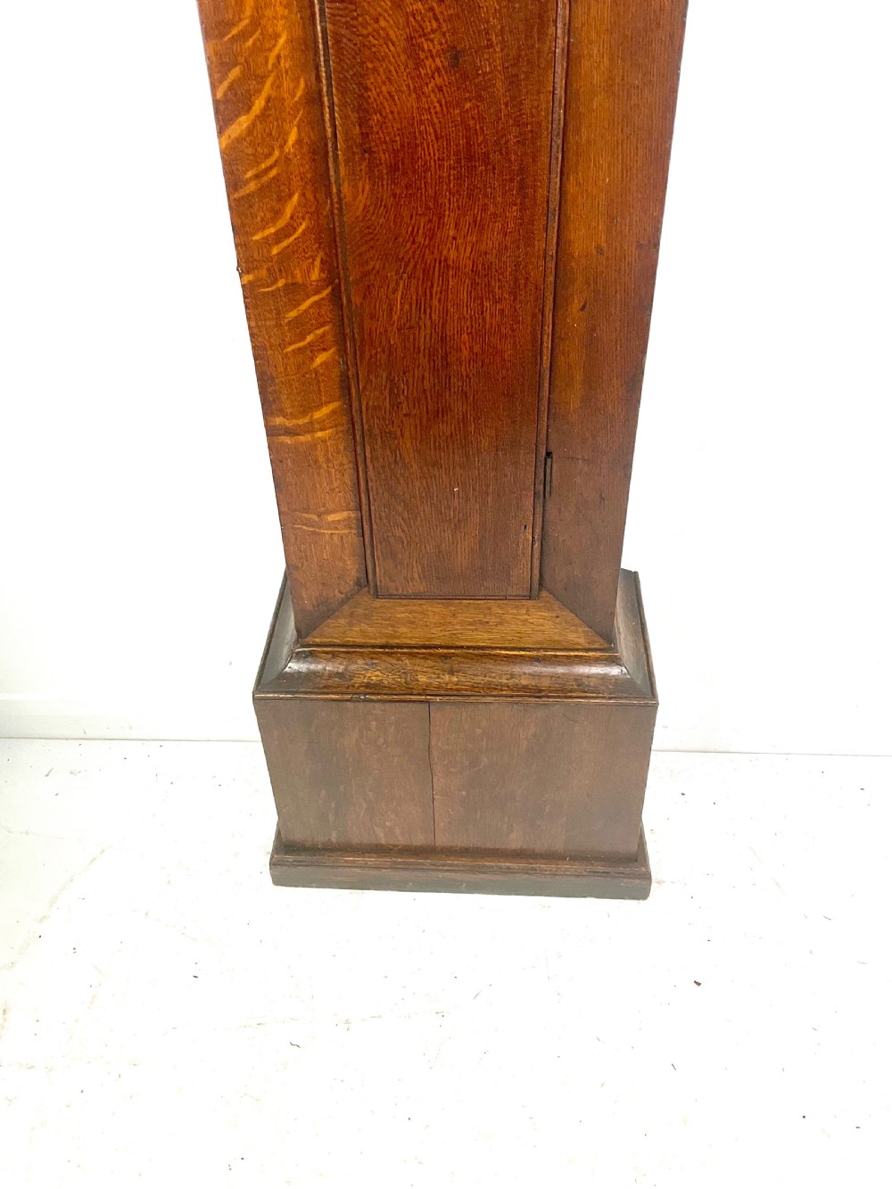 An antique Georgian oak longcase clock hood with a square brass dial, engraved numerals, corner spandrels, and turned side columns. View IV