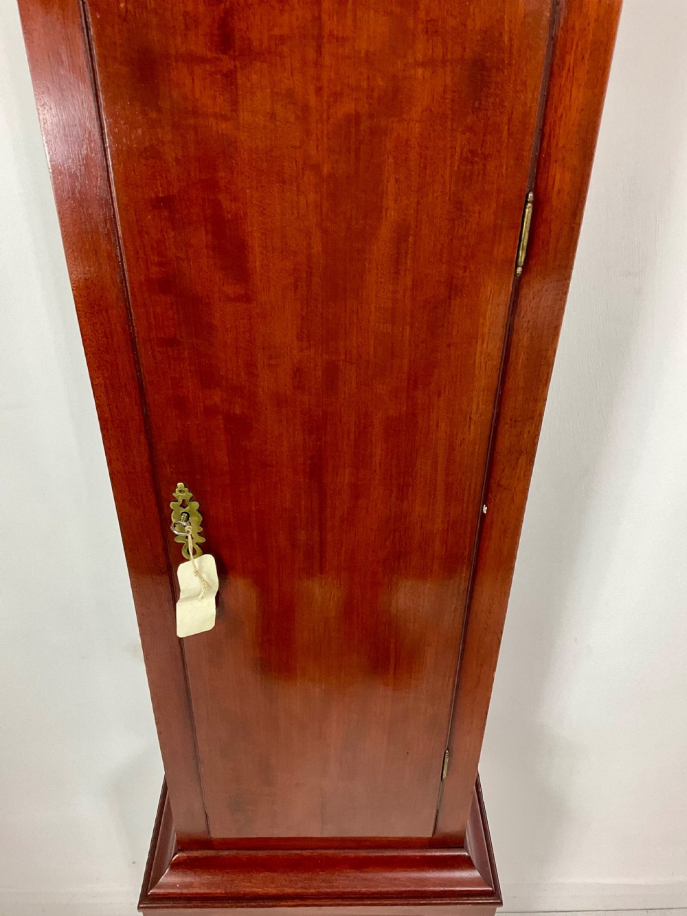 An 18th-century Georgian mahogany longcase clock featuring an arched brass dial with an engraved maker silvered boss and brass spandrels. View II