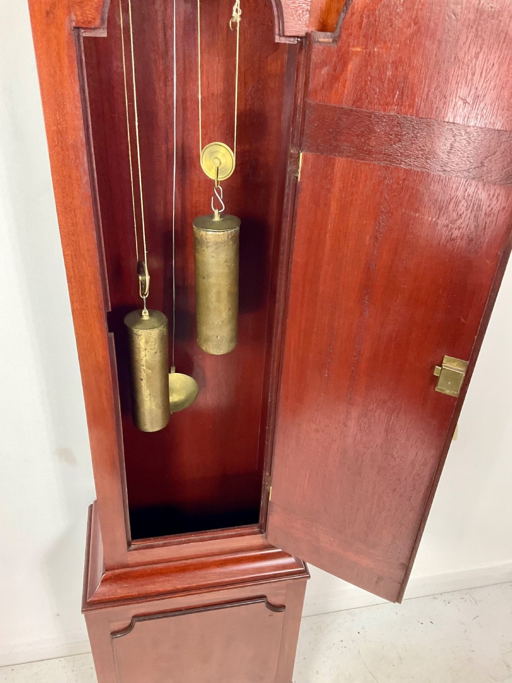 An 18th-century Georgian mahogany longcase clock featuring an arched brass dial with an engraved maker silvered boss and brass spandrels. View IV