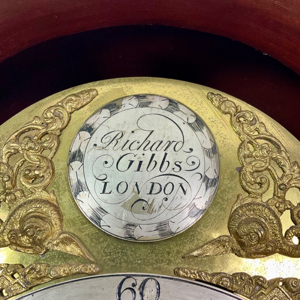 An 18th-century Georgian mahogany longcase clock featuring an arched brass dial with an engraved maker silvered boss and brass spandrels. View V