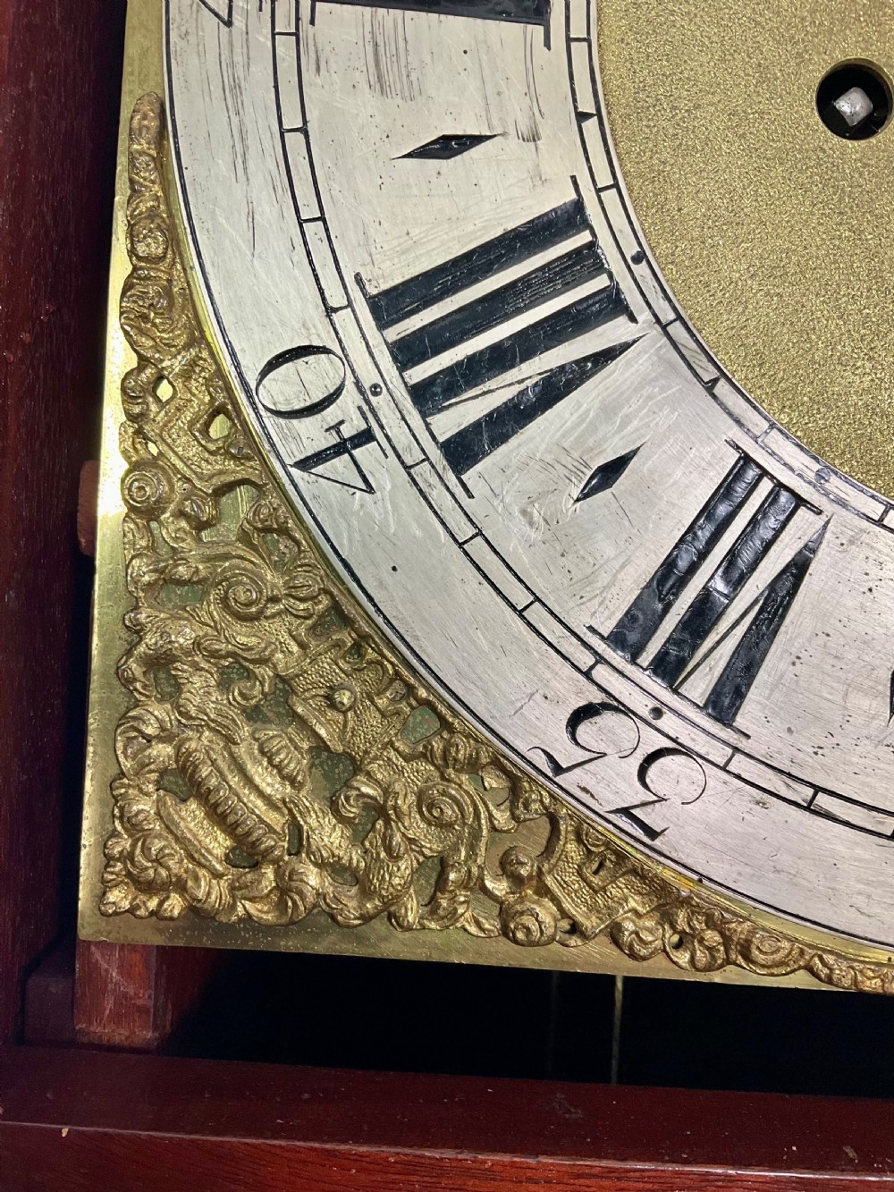 An 18th-century Georgian mahogany longcase clock featuring an arched brass dial with an engraved maker silvered boss and brass spandrels. View VIII