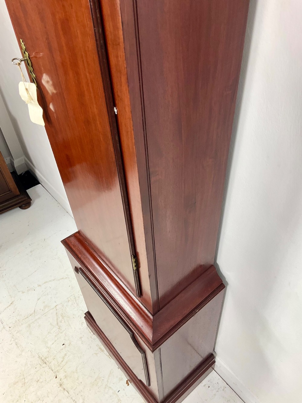 An 18th-century Georgian mahogany longcase clock featuring an arched brass dial with an engraved maker silvered boss and brass spandrels. View X