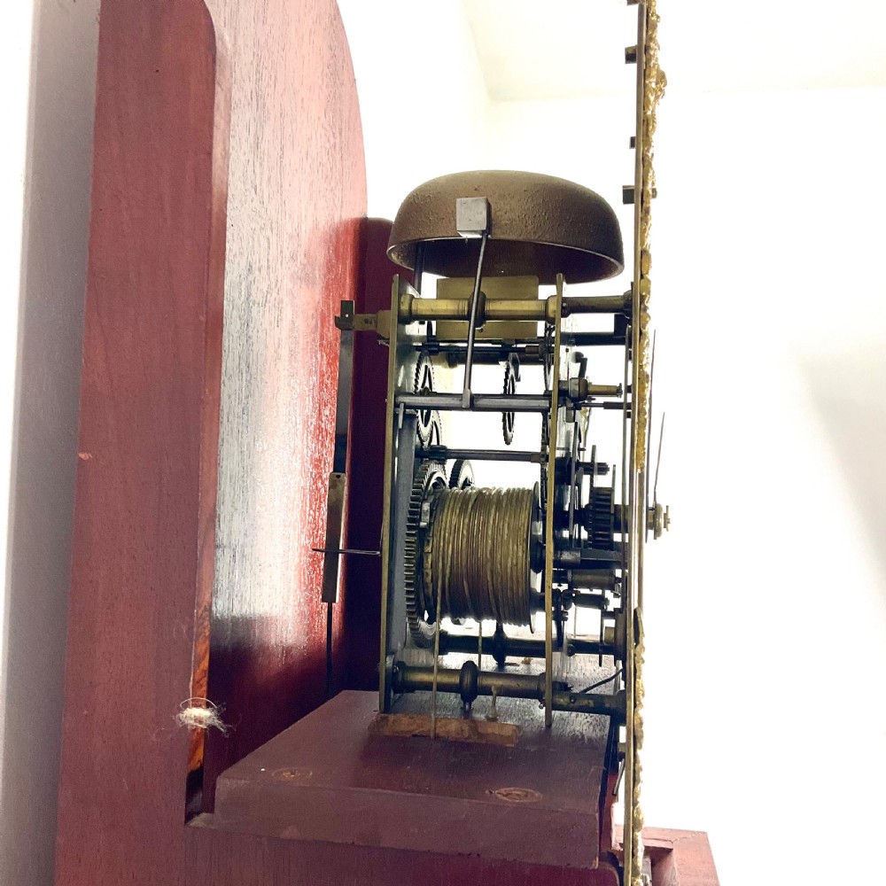An 18th-century Georgian mahogany longcase clock featuring an arched brass dial with an engraved maker silvered boss and brass spandrels. View XII