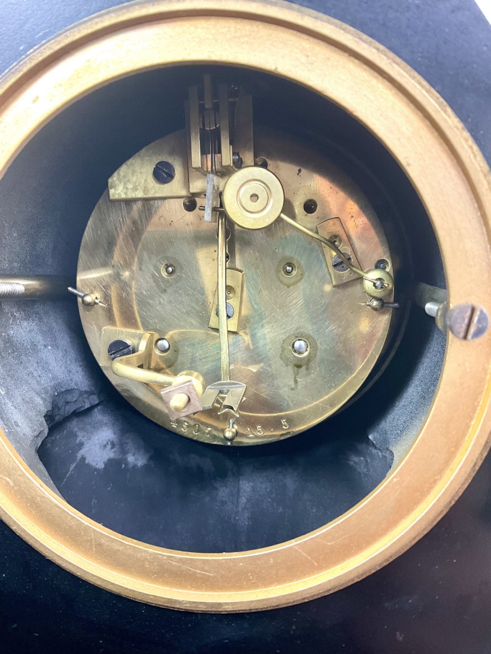 A black slate Egyptian Revival mantel clock featuring a central dial with red Roman numerals, flanked by two gilt bronze sphinxes and topped with a gilt urn finial. View XI