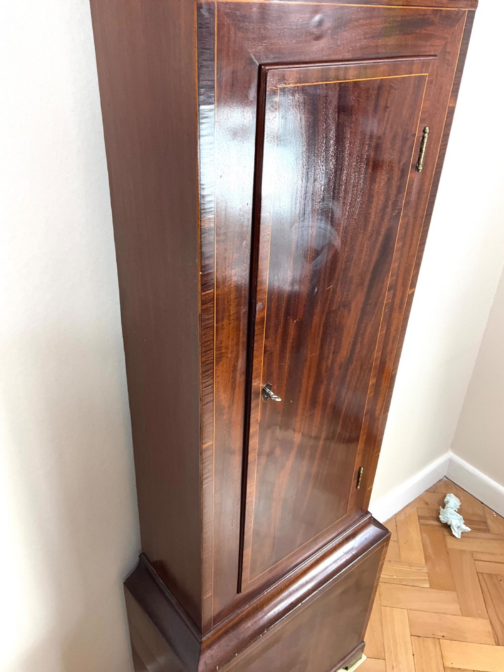 An upper hood section of a Georgian mahogany longcase clock featuring open fretwork pediments, brass finials, and a painted arch dial displaying a rocking ship automaton. View IX