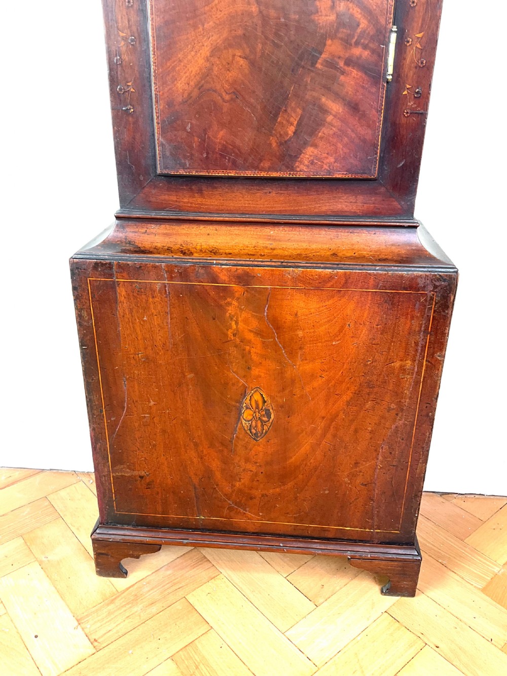 A Georgian mahogany longcase clock featuring a swan-neck pediment, painted dial, shell marquetry inlay, and reeded side columns. View III