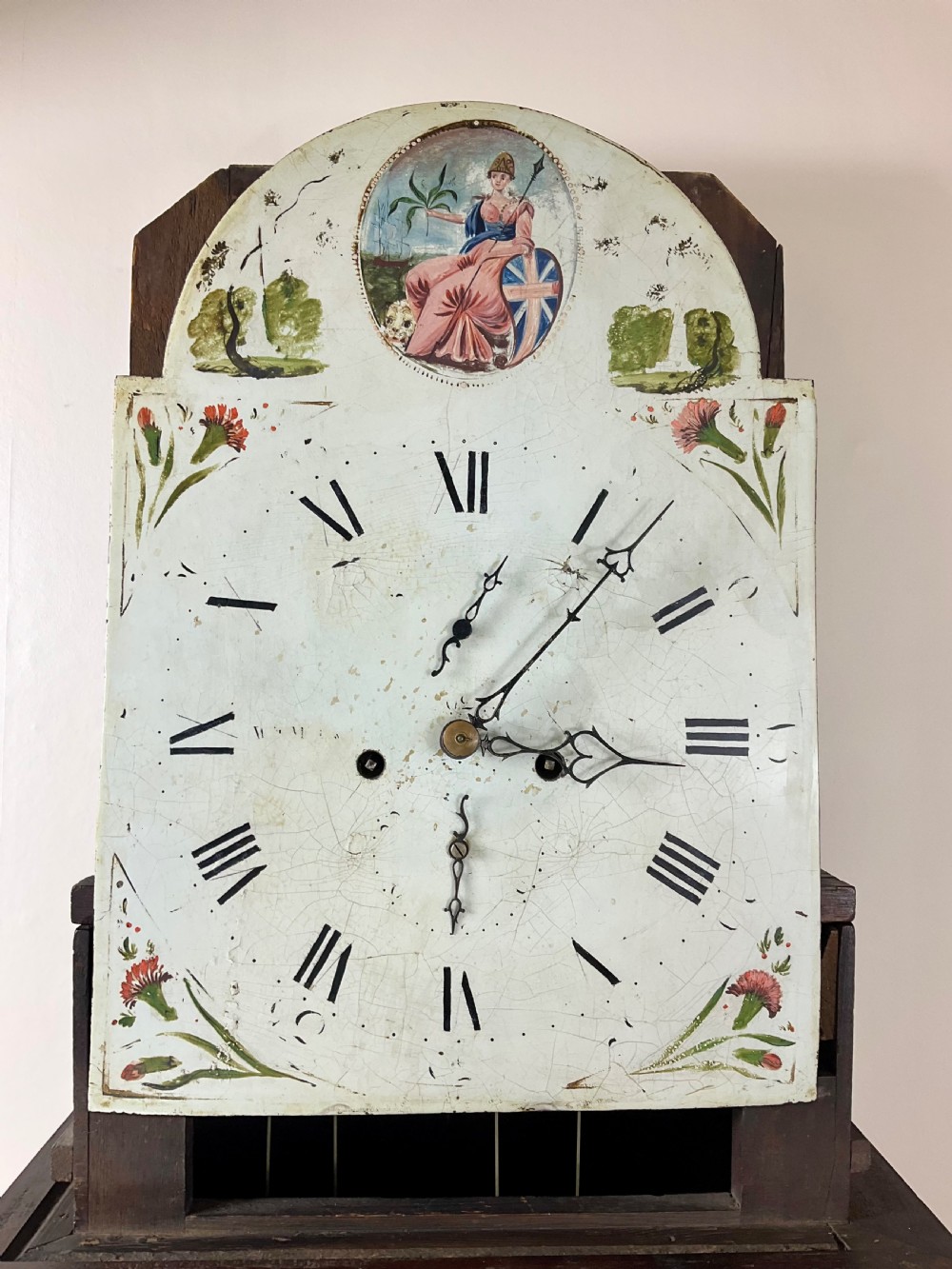 A Georgian mahogany longcase clock featuring a swan-neck pediment, painted dial, shell marquetry inlay, and reeded side columns. View IX