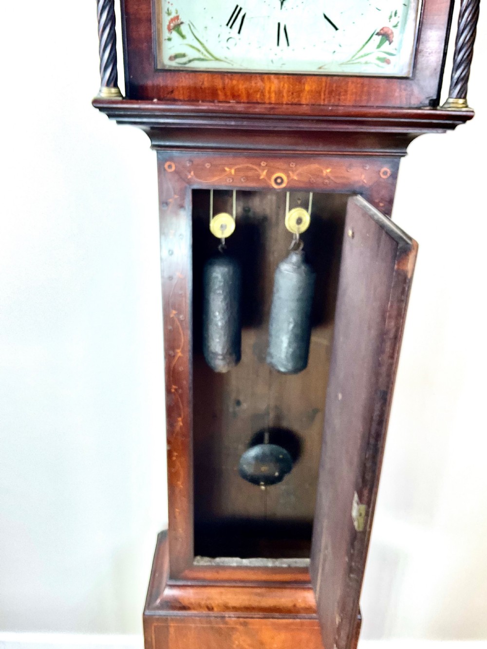 A Georgian mahogany longcase clock featuring a swan-neck pediment, painted dial, shell marquetry inlay, and reeded side columns. View XII