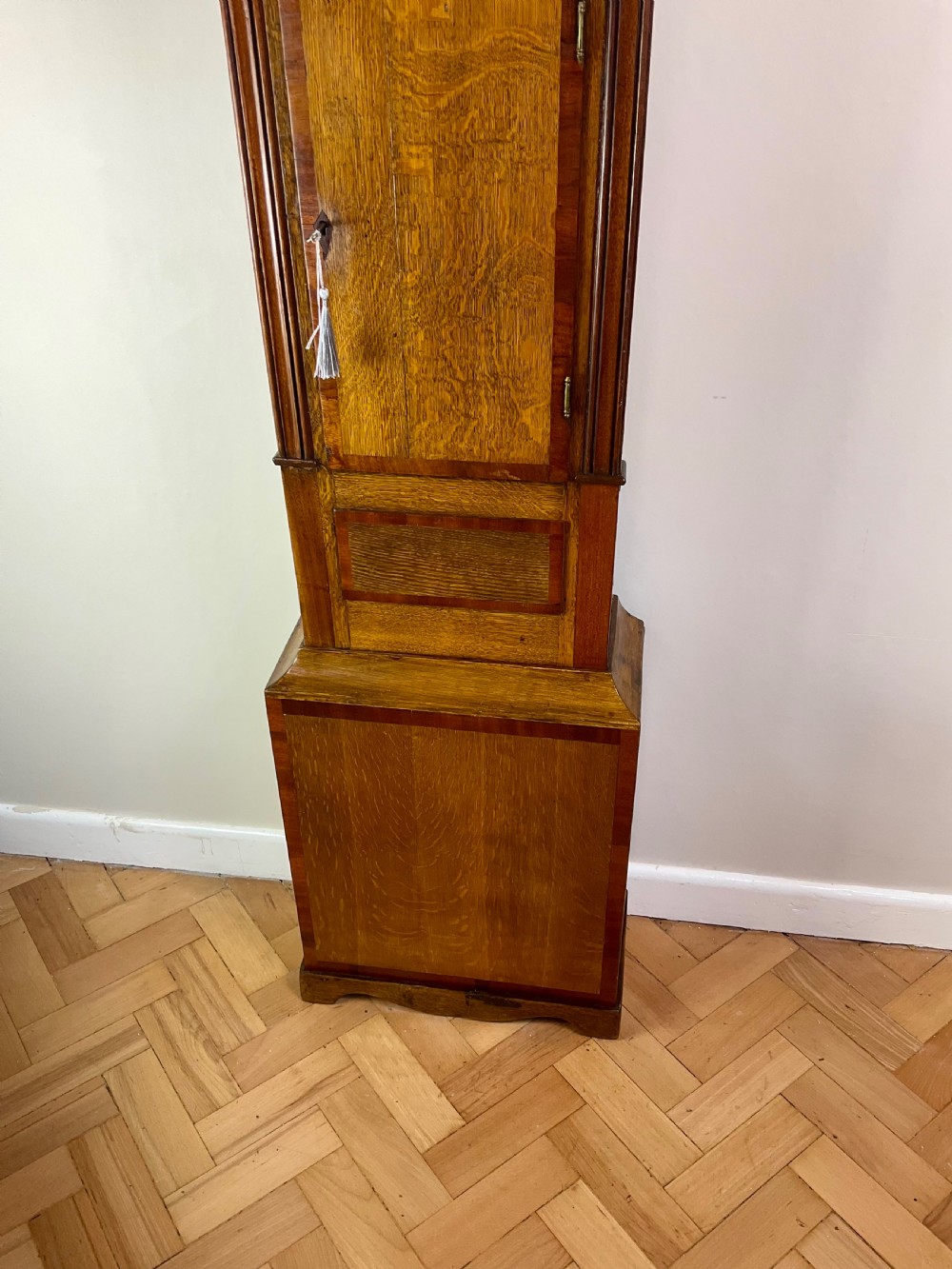 An 18th-century Georgian oak and mahogany longcase clock featuring a swan-neck pediment, fluted columns, and a painted dial face signed by Preddy of Langport. View V