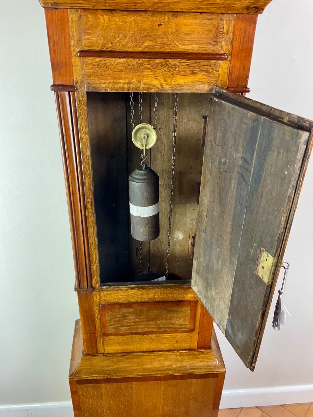 An 18th-century Georgian oak and mahogany longcase clock featuring a swan-neck pediment, fluted columns, and a painted dial face signed by Preddy of Langport. View VI
