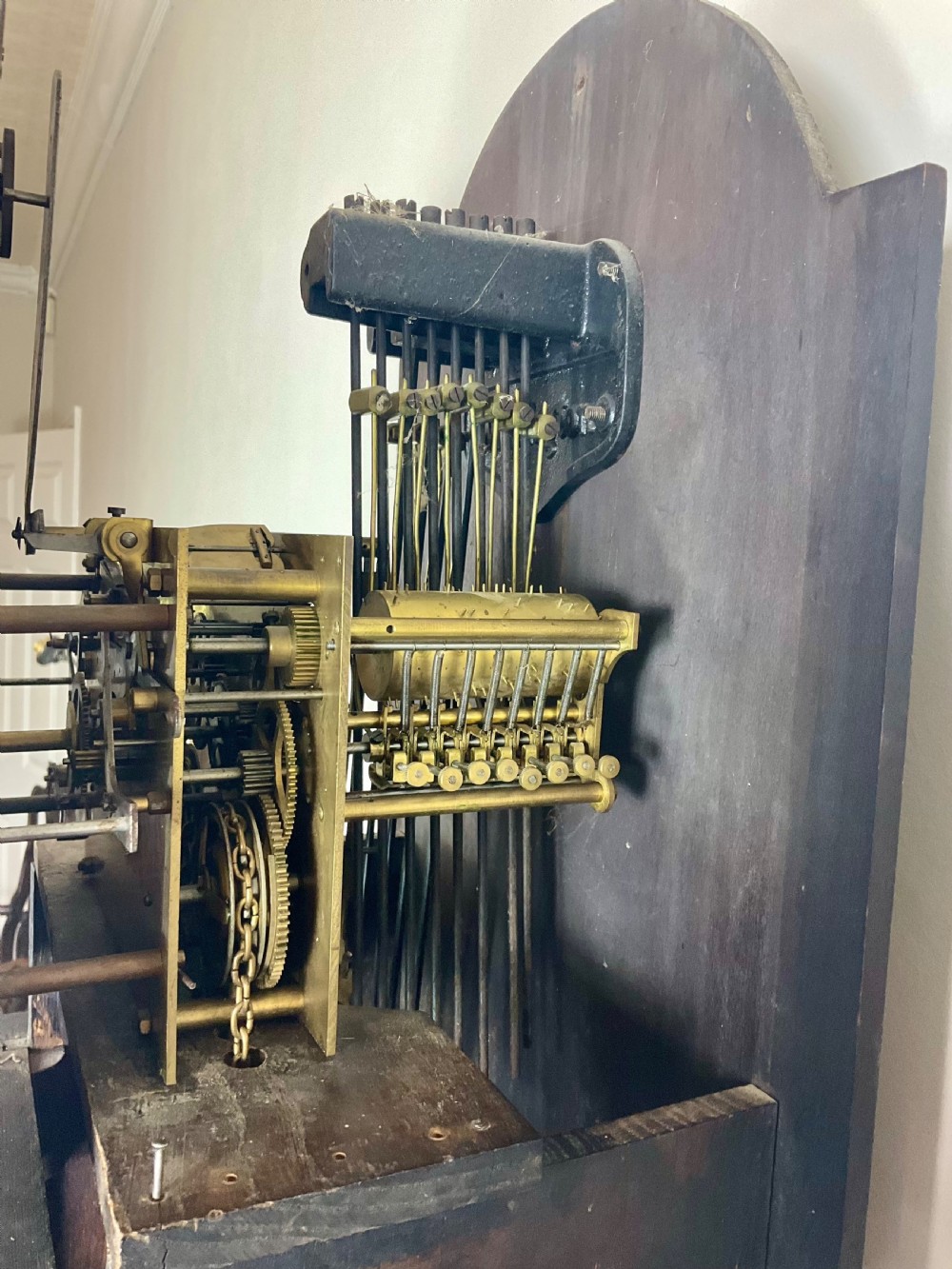 An antique dark oak longcase grandfather clock featuring an arched hood, brass dial with silvered chapter ring, and a tall panelled trunk. View XI