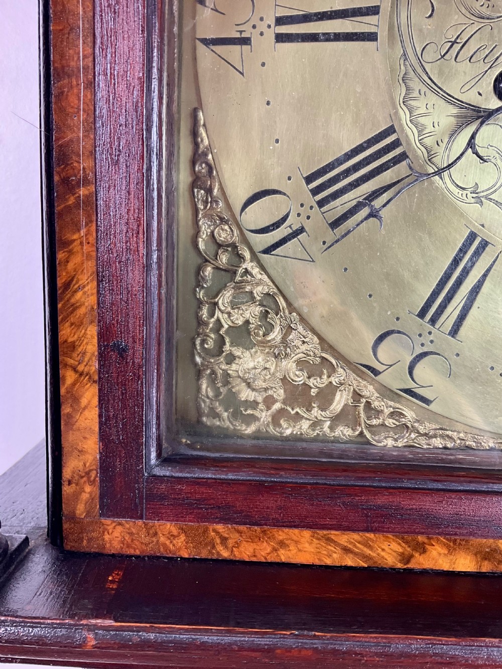 A tall Georgian dark oak longcase clock featuring an engraved brass square dial, fluted quarter-columns, and a shaped trunk door. View III