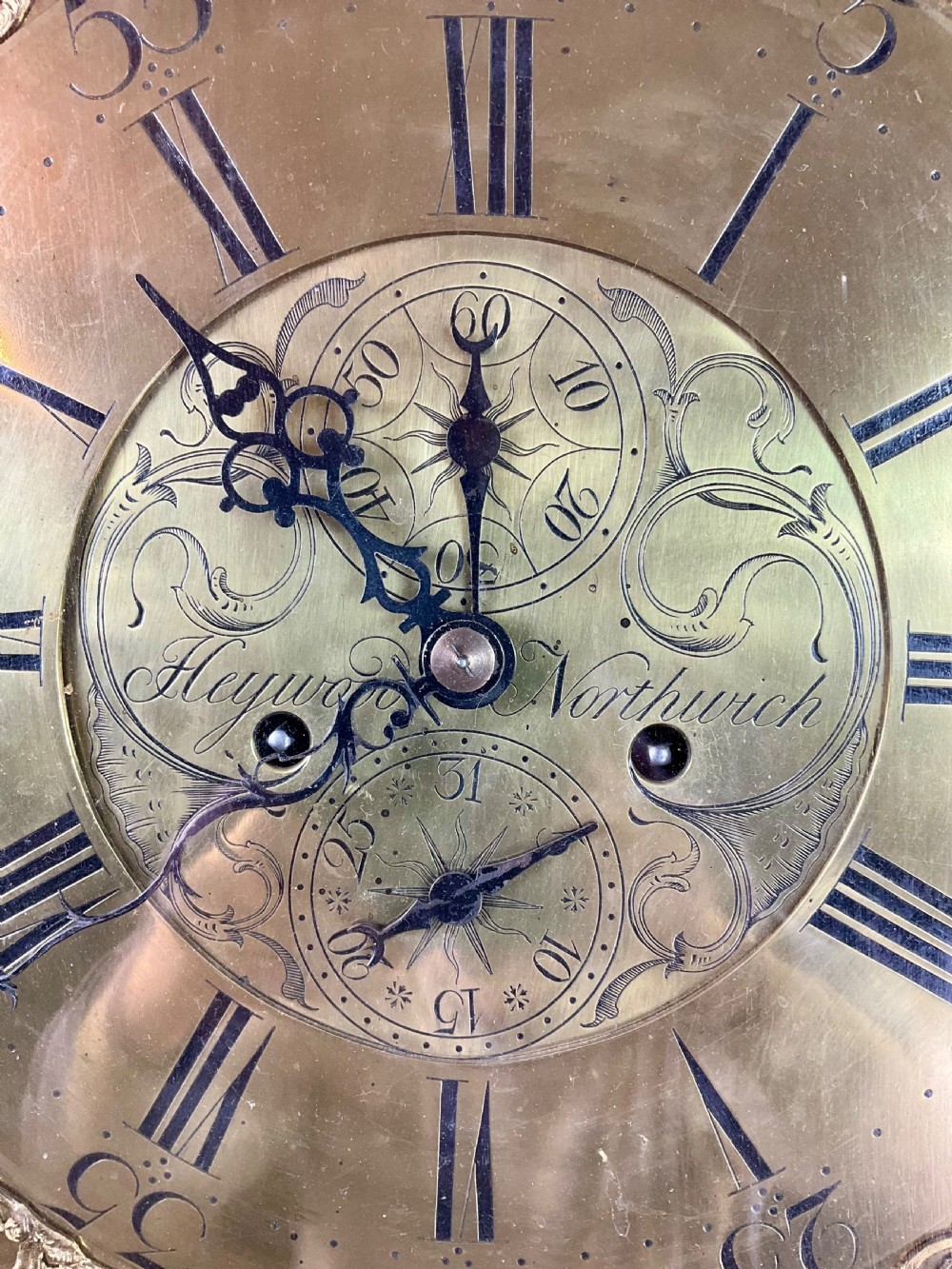 A tall Georgian dark oak longcase clock featuring an engraved brass square dial, fluted quarter-columns, and a shaped trunk door. View XVIII