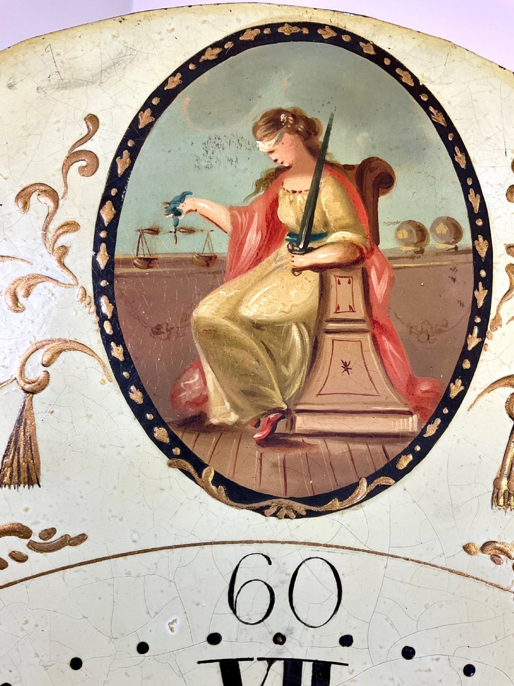A dark oak Georgian longcase clock featuring a painted arched dial with Roman numerals and three brass urn finials on the bonnet. View XIII