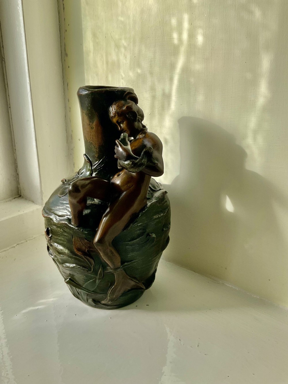 A dark patinated bronze Art Nouveau vase featuring a relief sculpture of a reclining female nymph on its side. View III