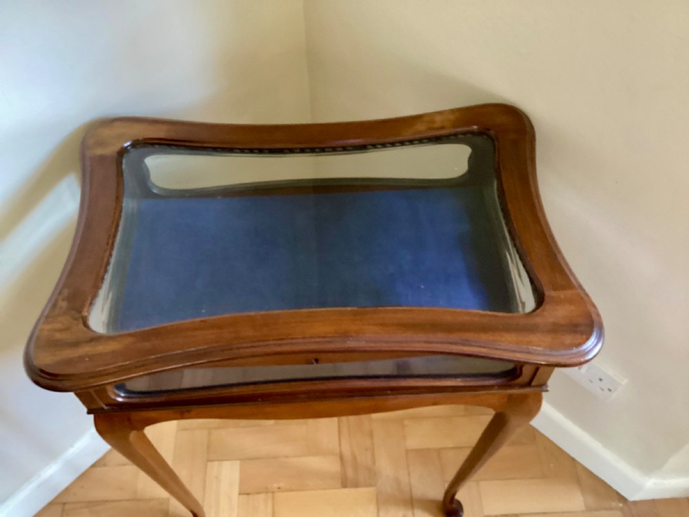 A mahogany bijouterie table featuring curved cabriole legs, glass sides, a glazed top lid, and a blue fabric lining within. View VI