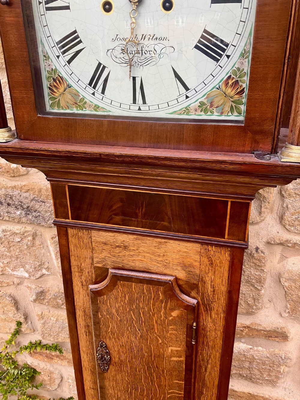 A Georgian oak and mahogany longcase clock featuring a swan-neck pediment, fluted hood columns, and a painted square dial. View IV