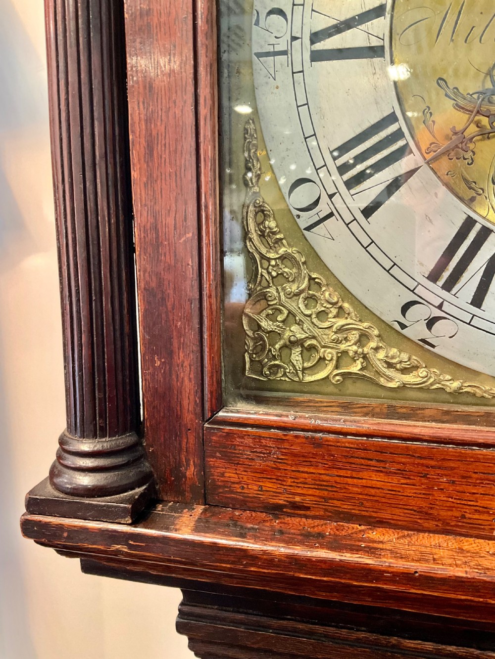 A Georgian mahogany longcase clock featuring geometric wood inlay, a brass dial with a silvered chapter ring, and turned columns flanking the hood. View IV