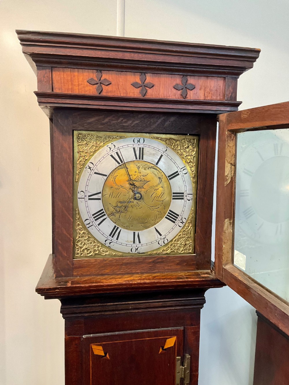 A Georgian mahogany longcase clock featuring geometric wood inlay, a brass dial with a silvered chapter ring, and turned columns flanking the hood. View VI
