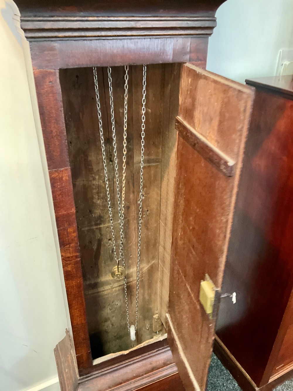 A Georgian mahogany longcase clock featuring geometric wood inlay, a brass dial with a silvered chapter ring, and turned columns flanking the hood. View VIII