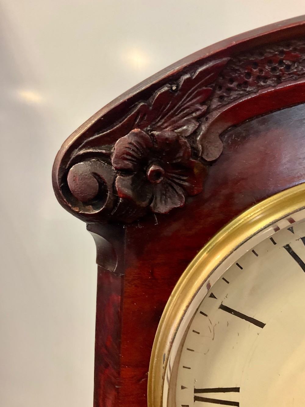 A 19th-century mahogany fusee bracket clock featuring an arched case with hand-carved floral spandrels, flame mahogany veneer, and a circular cream dial with Roman numerals. View VI